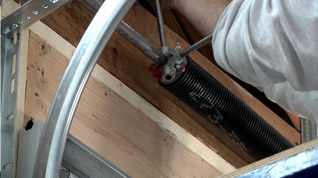 Garage for technician using 2 winding bars to properly and safely wind a garage door torsion spring.