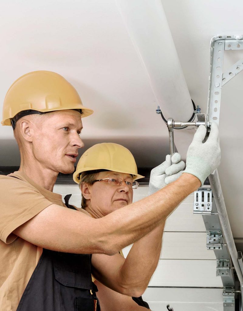 Solution education stock image garage door technicians working together.